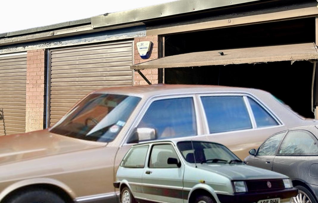 vintage cars next to an up and over lock up storage garage 