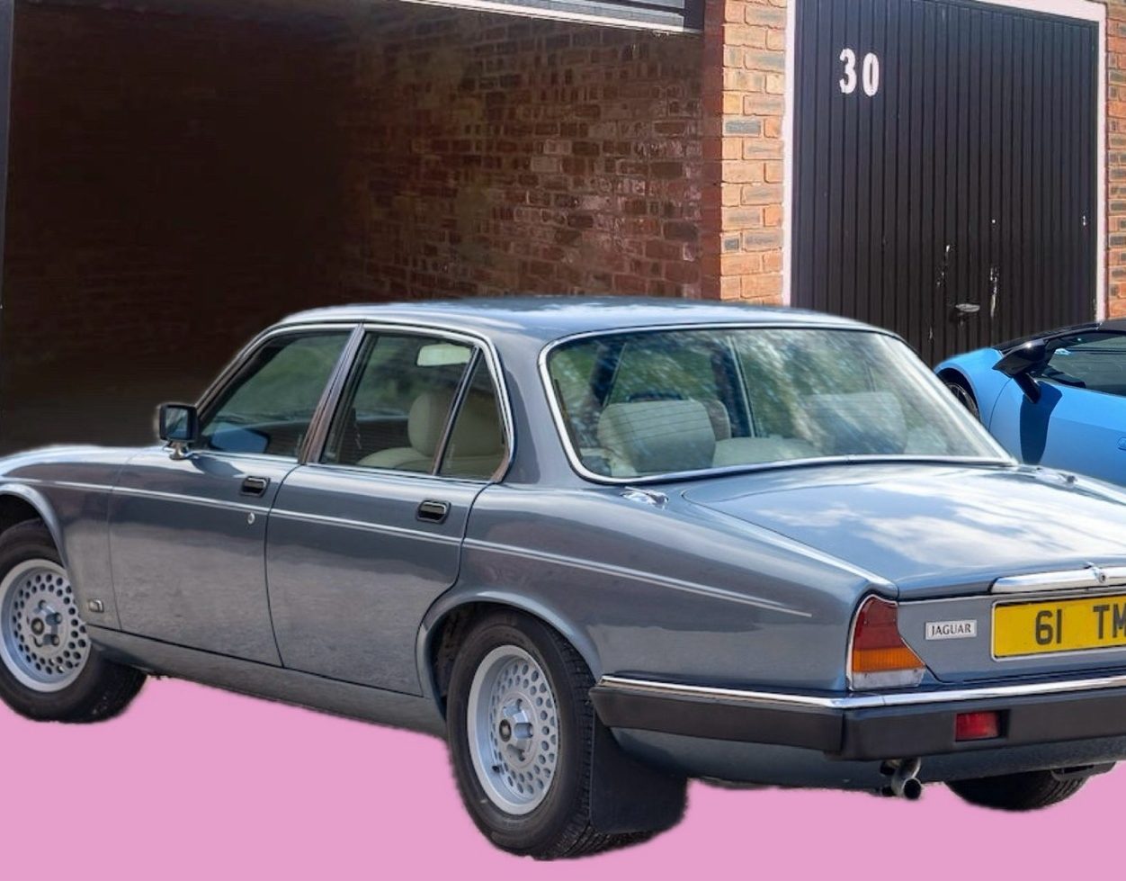 classic car next to a lock up garage