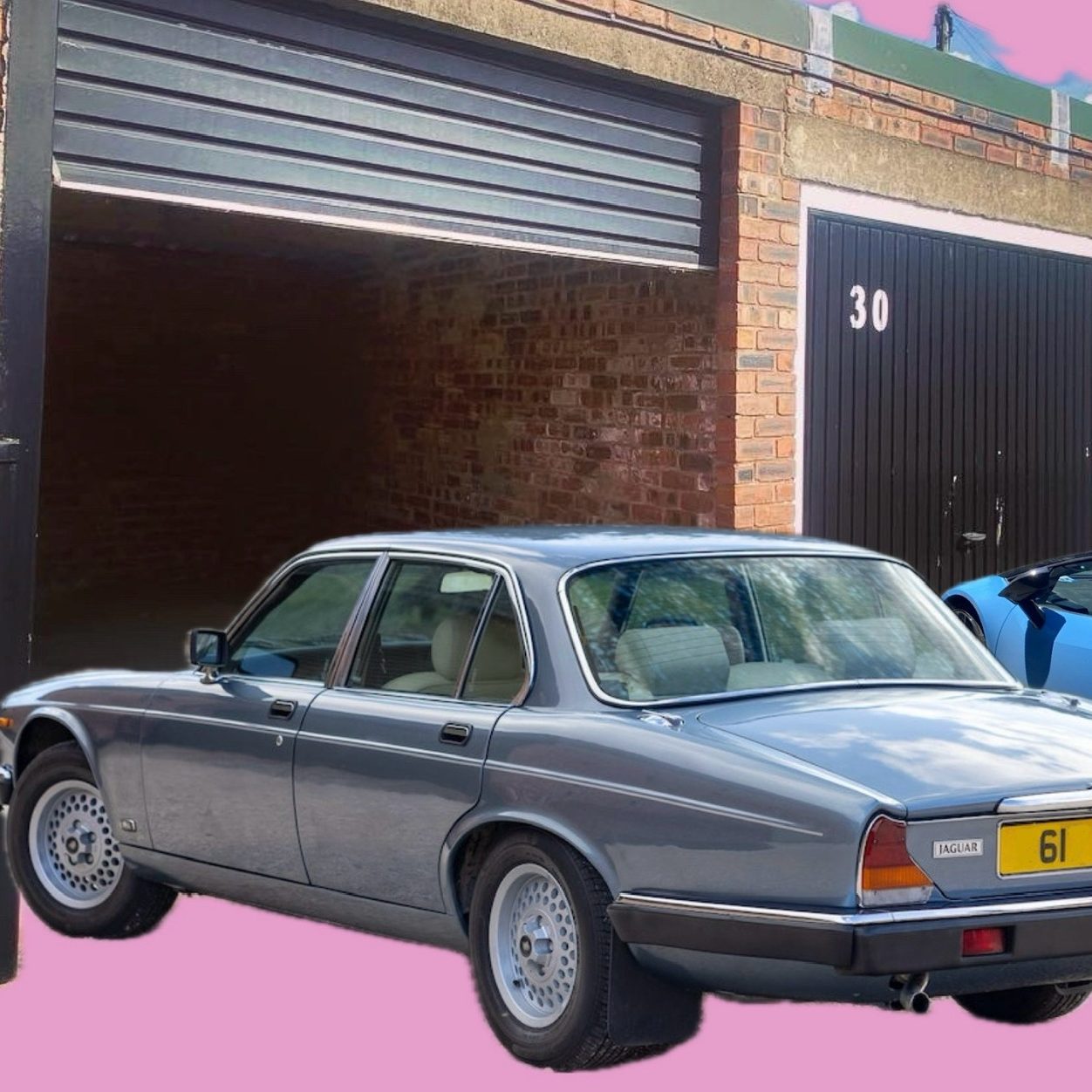 A jaguar sports car next to a lock up garage