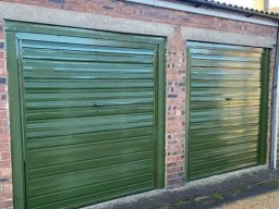 two lock up garages with green up and over doors