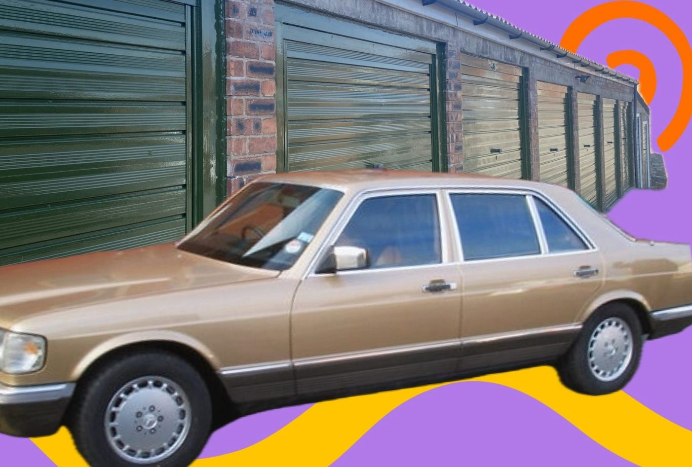 a classic motor car parked beside a lock up garage for rent